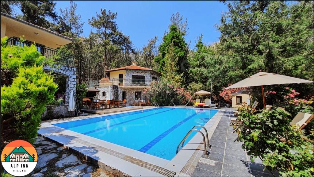 a swimming pool in front of a house at Alp inn Butik Apart ve Restoran in Marmaris