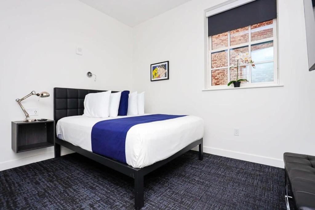 a bedroom with a bed with a blue and white comforter at Modern Studio in Historic Boston - Unit #103 in Boston