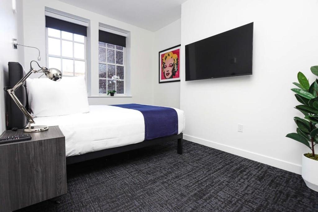 a hotel room with a bed and a tv at Stylish Studio in Fenway Neighborhood - Unit #306 in Boston