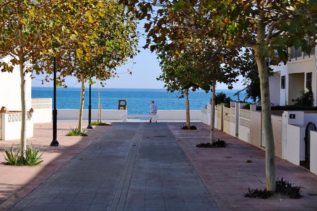 ラ・カラ・デ・ミハスにあるCasa Magda and Lukeの海の横の歩道を歩く者