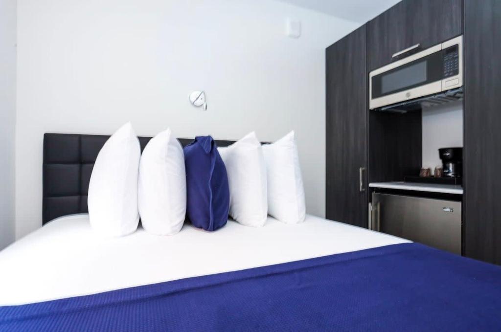 1 dormitorio con 1 cama con almohadas azules y blancas en Modern Studio in Historic Boston - Garden Unit #2 en Boston