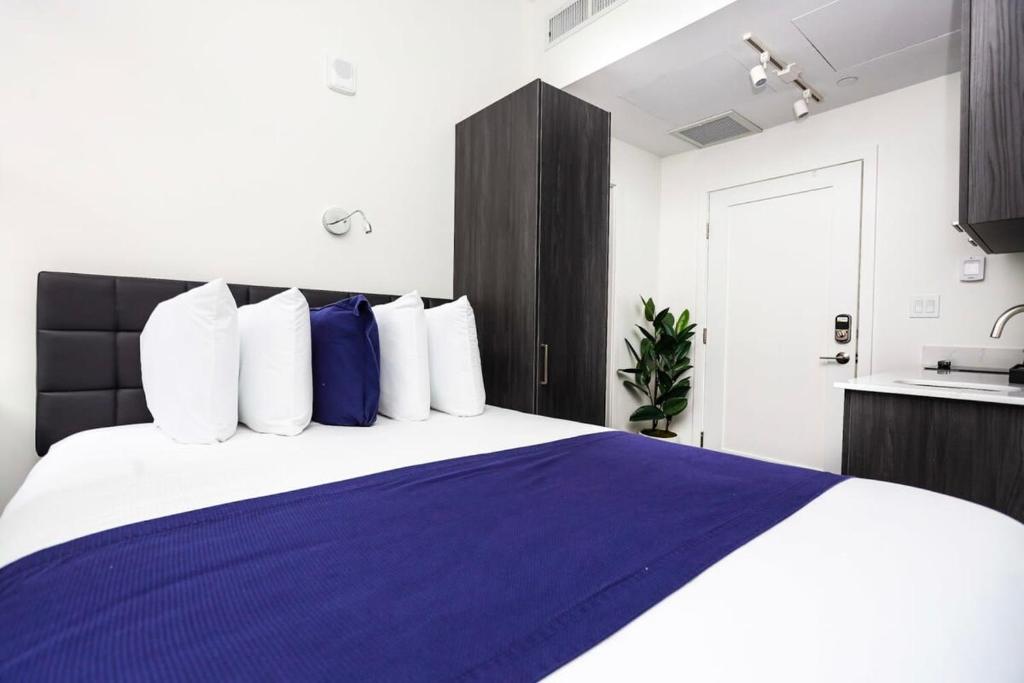 um quarto com uma cama grande e almofadas azuis e brancas em Stylish Studio in Historic Boston - Unit #404 em Boston