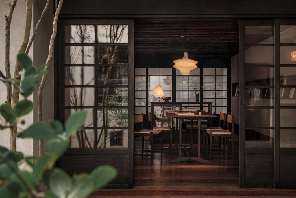 uma sala de jantar com uma mesa e cadeiras e uma porta em Anyu Hotel Hangzhou em Hangzhou