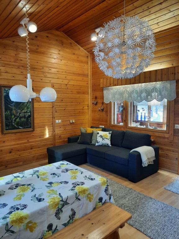 a bedroom with a bed and a couch and a chandelier at Holiday Home Samanitieva in Enontekiö