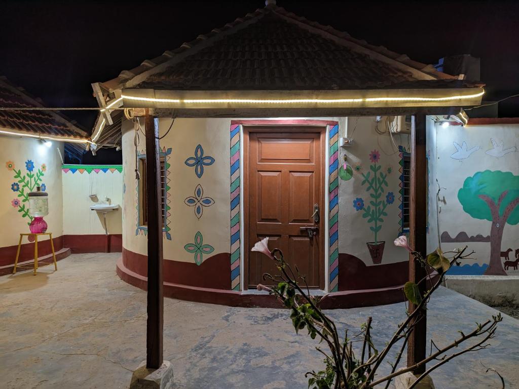 ein kleines Haus mit einer Tür und Blumen an der Wand in der Unterkunft Vijay Homestay in Dhordo