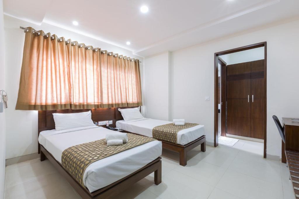 Postel nebo postele na pokoji v ubytování Sanctum Suites BEL Road Bangalore