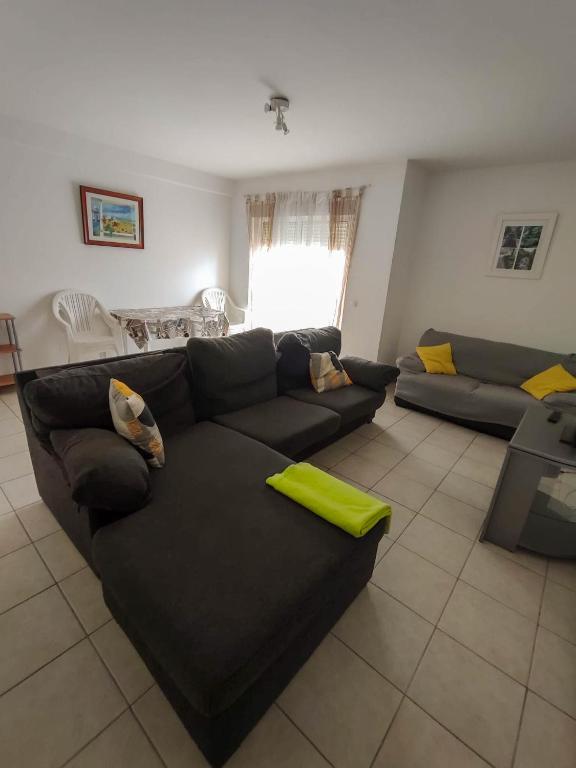 een woonkamer met een zwarte bank en een tv bij Quinta das Oliveiras 4 Bedrooms with Balcony in Portimão
