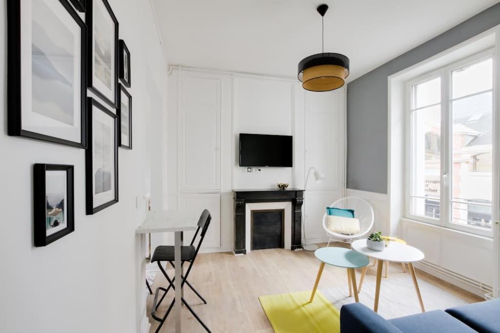 uma sala de estar com um sofá e uma mesa em Aux Clefs des Sacres - Le Chabaud 5 em Reims