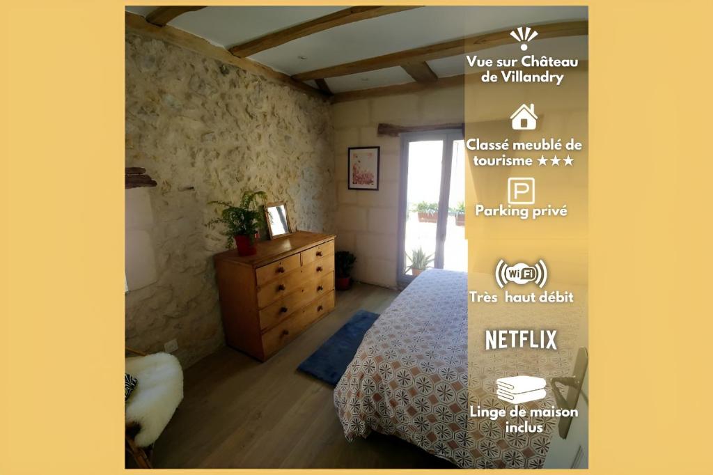 una señal para un dormitorio con cama y tocador en La Bienheureuse Maison, vue sur le Château de Villandry en Villandry