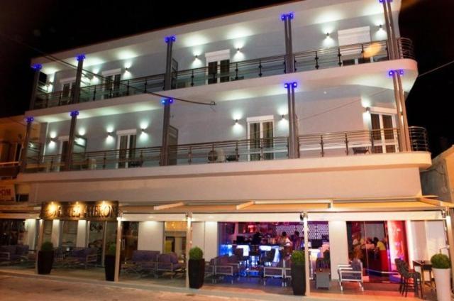 a large white building with a balcony on top of it at Hotel Aheron in Kanallaki