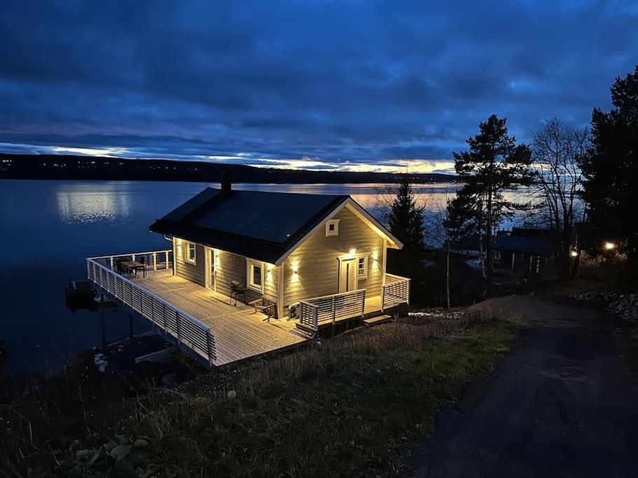 a house on a dock on a lake at night at Lake house by Storsjön in Östersund