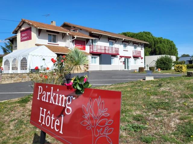 a red sign in front of a building at Hotel Le Cormier 9 in Cholet