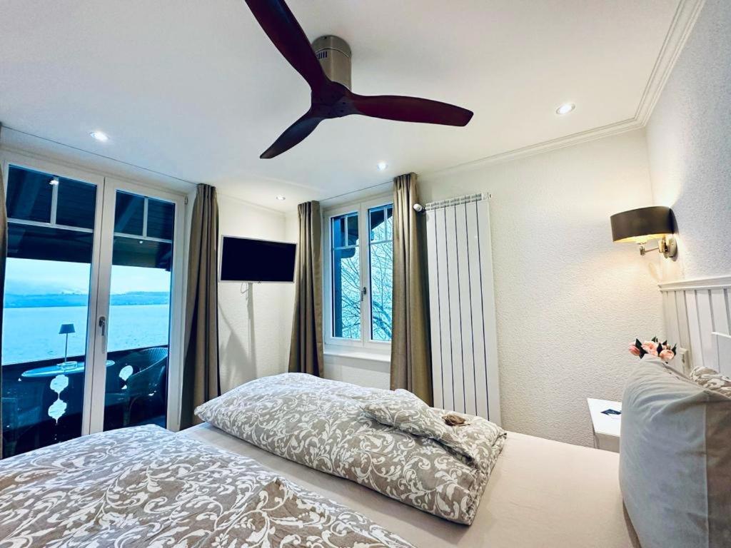 1 dormitorio con 1 cama y ventilador de techo en Boutique Hotel Niesenblick - direkt am Thunersee gelegen mit SELF CHECK IN & digitaler Rezeption, en Oberhofen am Thunersee