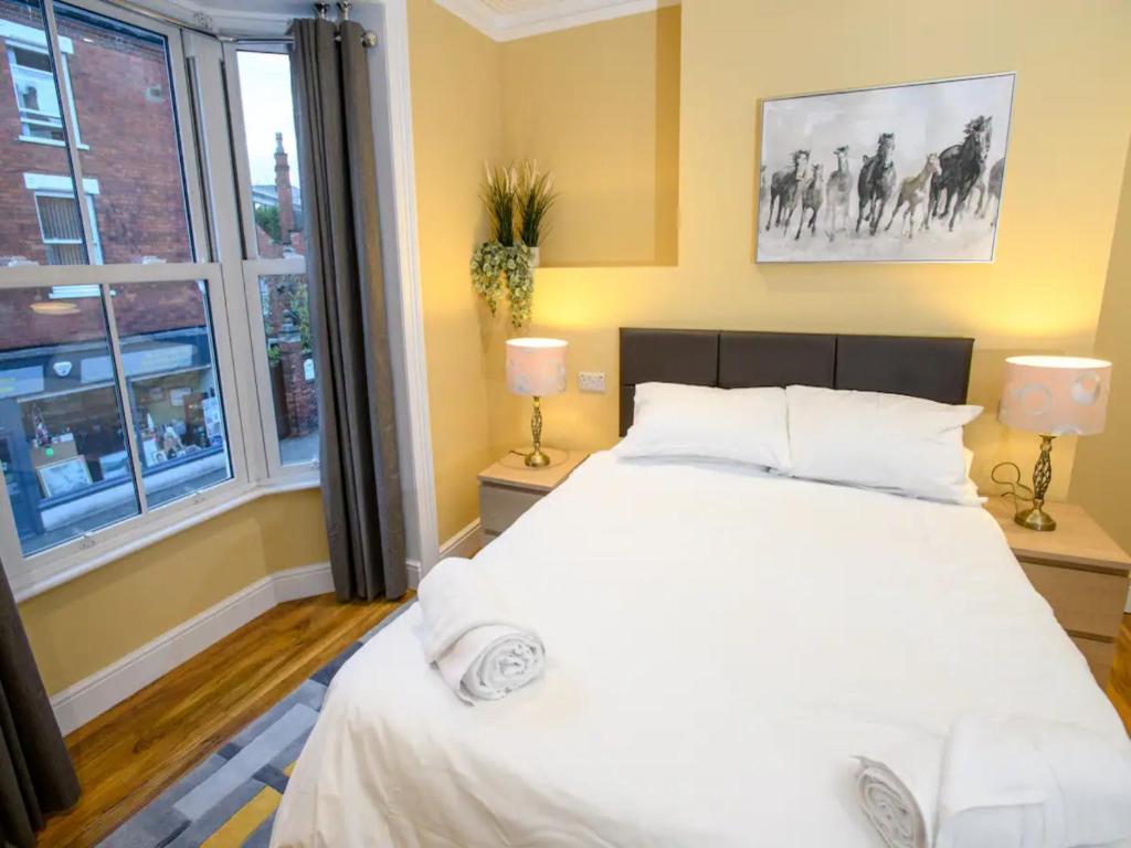 a bedroom with a large white bed and a window at Pass the Keys The Sunny Room at Tavmar Apartments in Lincoln