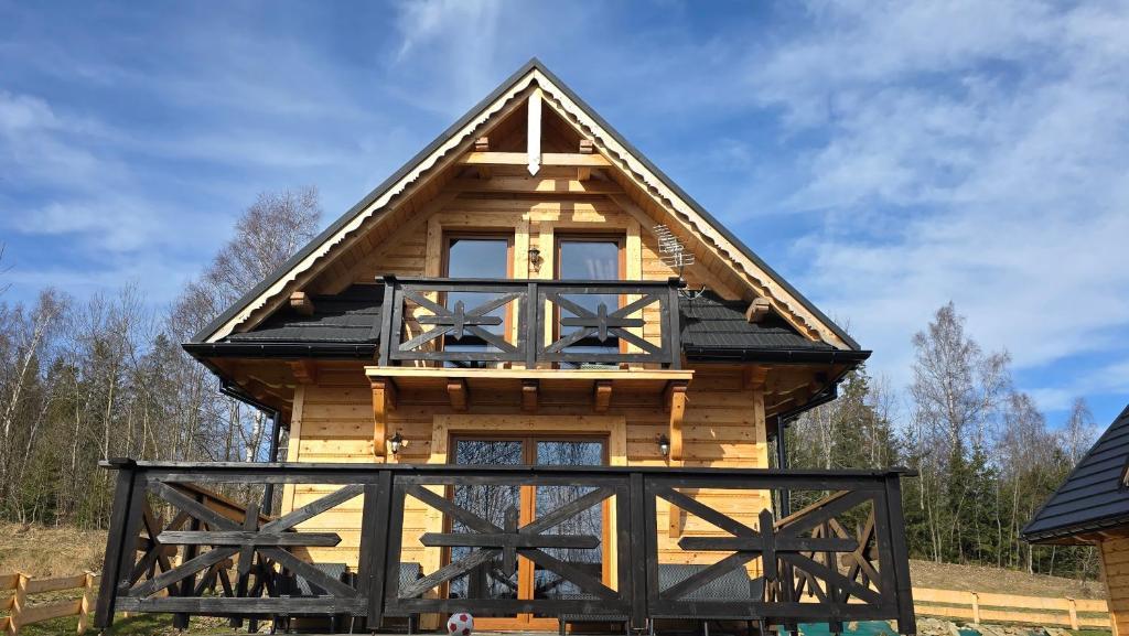 una cabaña de madera con techo de gambrel en Domek pod lasem-Orawskie Ranczo, en Harkabuz
