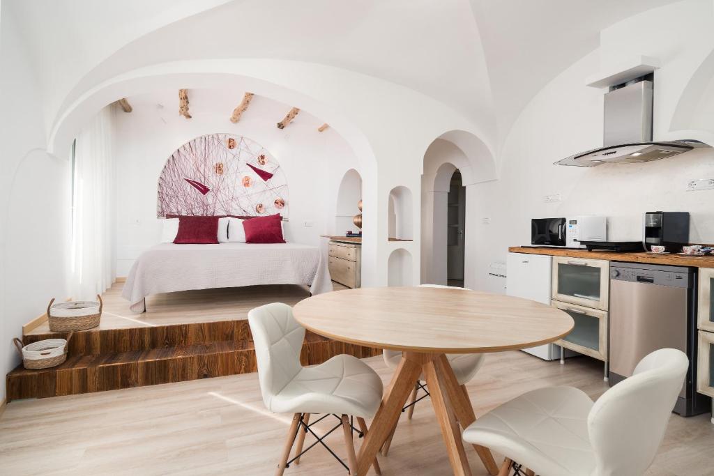 a kitchen and bedroom with a table and a bed at Giojas125- Monolocale per 2 persone in Orosei