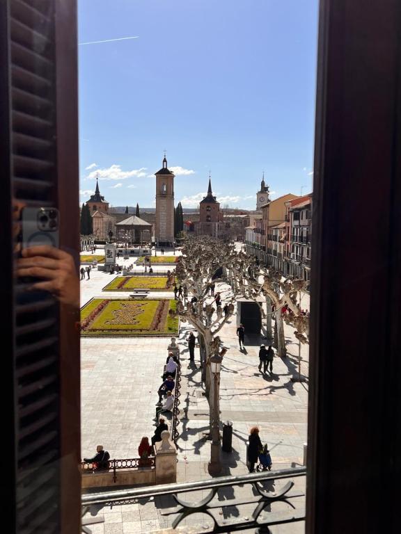 una persona tomando una foto de una ciudad desde una ventana en Sueña en la Plaza Cervantes, en Alcalá de Henares
