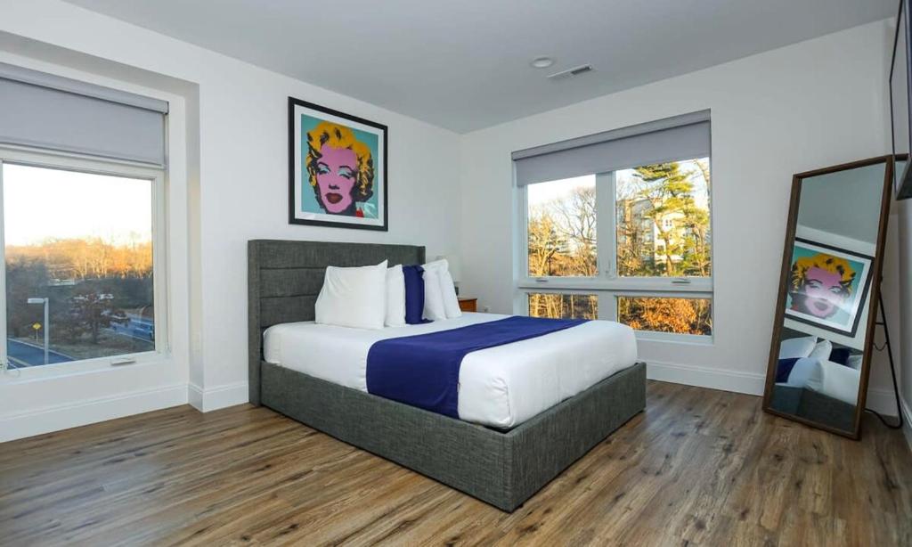 - une chambre avec un grand lit et 2 fenêtres dans l'établissement Luxury Apartment w Office & Gym, à Peabody