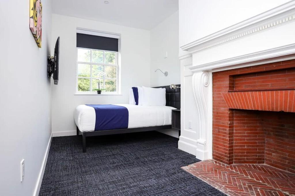 a bedroom with a bed and a brick fireplace at Stylish Hotel Room in Boston's Fenway - Unit #104 v2 in Boston