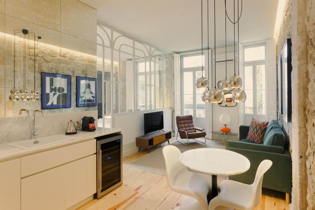 cocina y sala de estar con mesa y sofá en Laranjais Boutique Suites & Apartments Porto, en Oporto