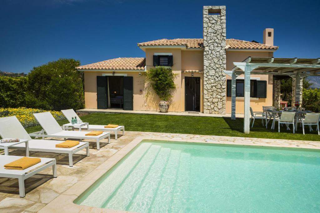 eine Villa mit einem Pool vor einem Haus in der Unterkunft Xenia Villa in Argostoli