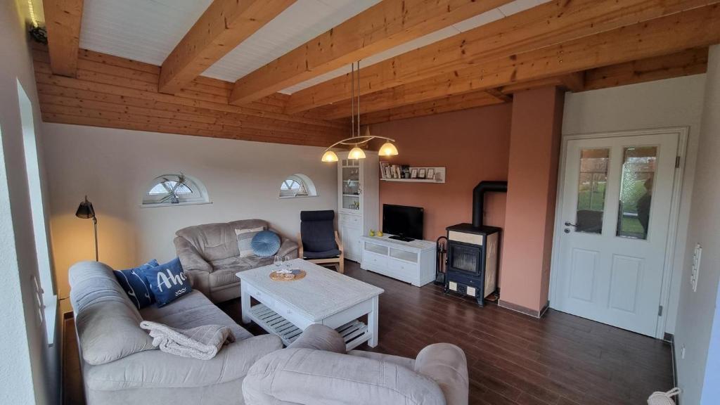 a living room with two couches and a fireplace at Ferienhaus-Sommerwind in Neßmersiel