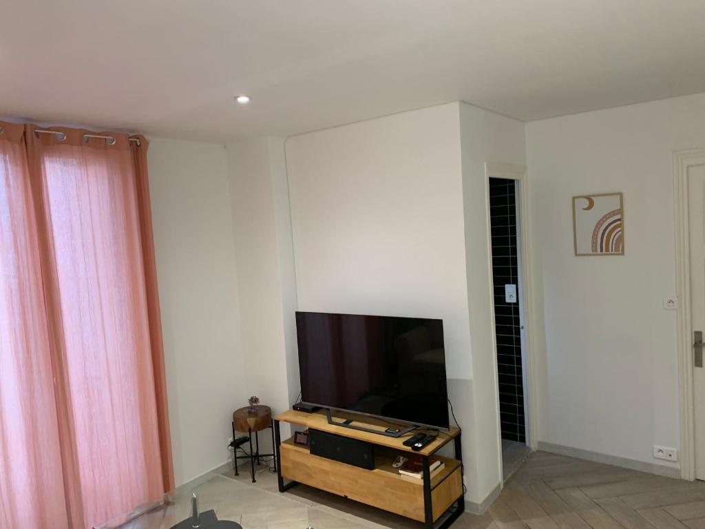 un salon avec une télévision à écran plat sur un mur dans l'établissement Charmant Appartement à 5 minutes de la plage, à Nice