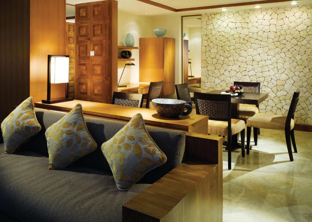 a living room with a couch and a dining room at Grand Hyatt Bali in Nusa Dua