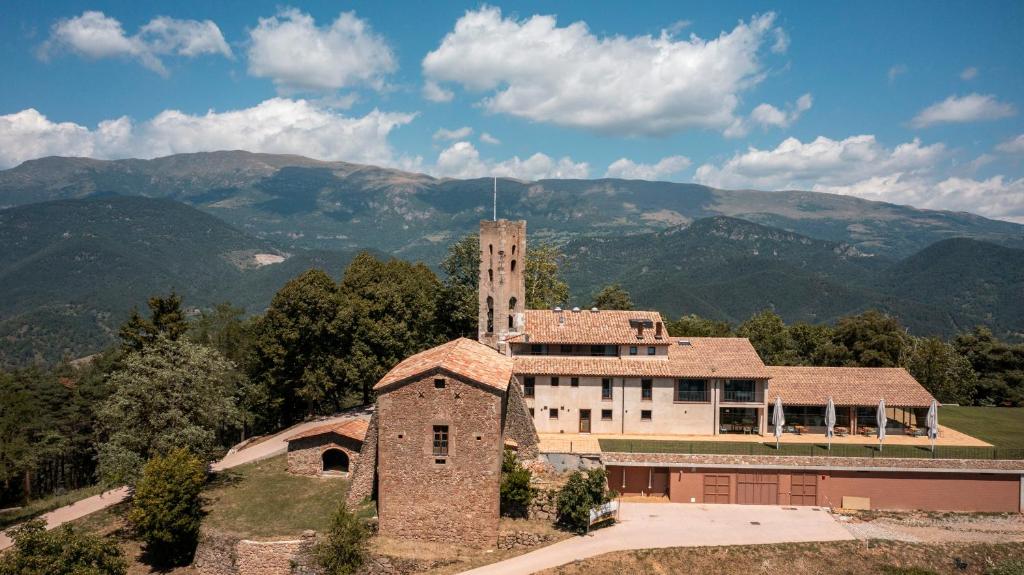 un antiguo edificio con una torre en la cima de una montaña en Abbatissa Hotel Restaurant en Sant Joan de les Abadesses