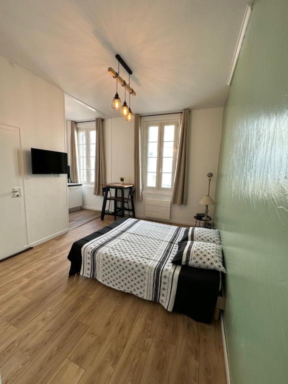 - une chambre avec un lit et une table dans l'établissement Le Mirabelle, à Saintes