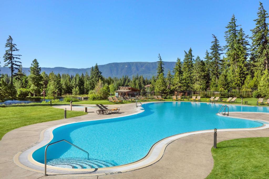 a large swimming pool in a park with trees at Suncadia Resort in Cle Elum