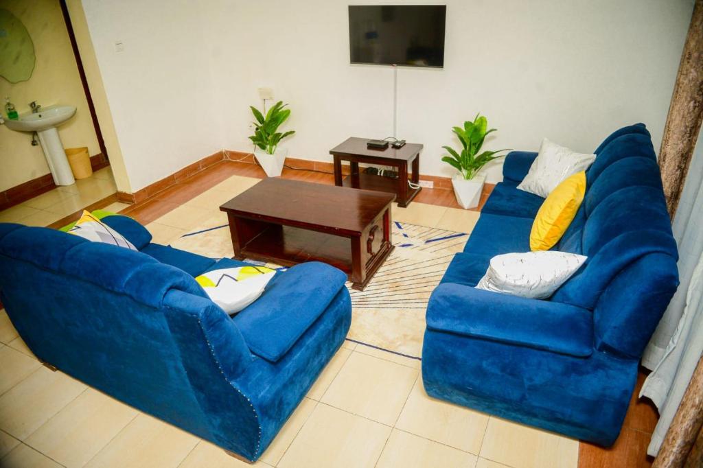 a living room with two blue couches and a table at Kothuondo's 2 &3edrooms all ensuite apartment in Kisumu