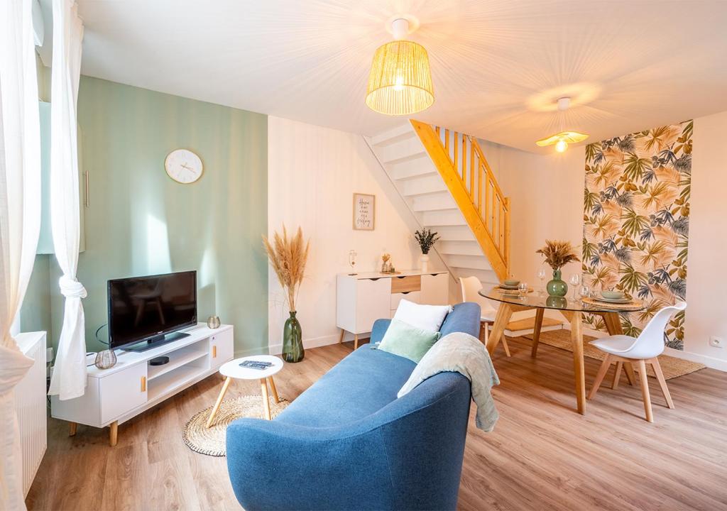 a living room with a blue couch and a table at Maison cosy et chaleureuse in Marly