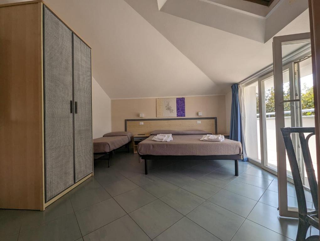 sypialnia z 2 łóżkami i dużym oknem w obiekcie Hotel Doria w mieście Bellaria-Igea Marina