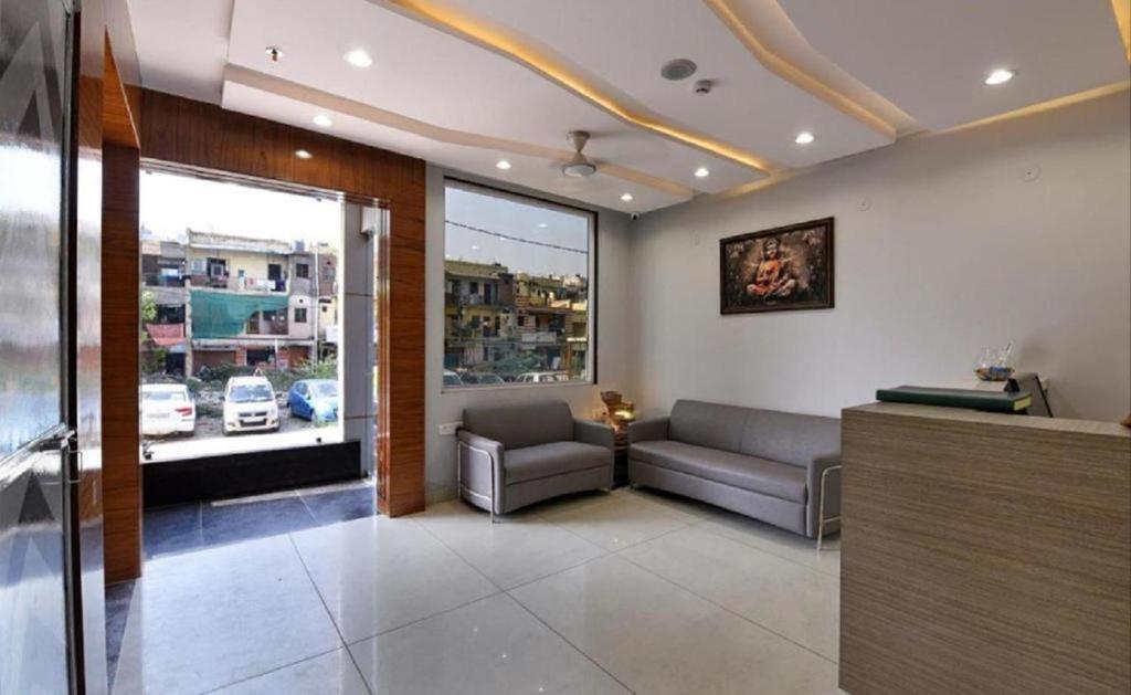 a waiting room with a couch and a window at Hotel The Emporio A Corporate Suites in Ghaziabad