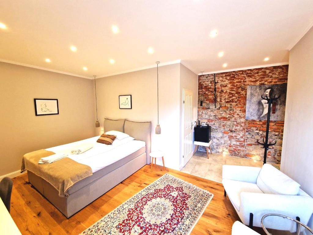 a bedroom with a bed and a brick wall at Das Gutshaus in Knittelfeld