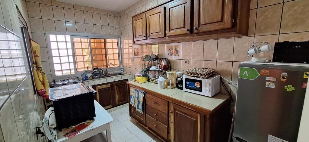 uma cozinha com armários de madeira e um frigorífico de aço inoxidável em RÉSIDENCE VGP LOGPOM em Douala