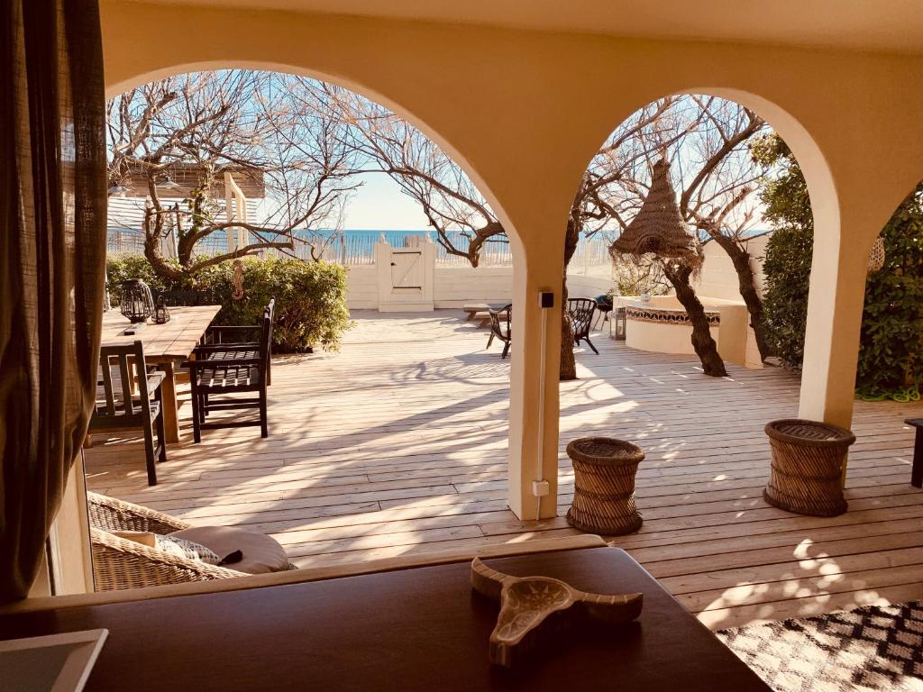 uma vista para um pátio com uma mesa e cadeiras em Mas Andalou Fabuleuse première ligne de mer, plage privative em Frontignan