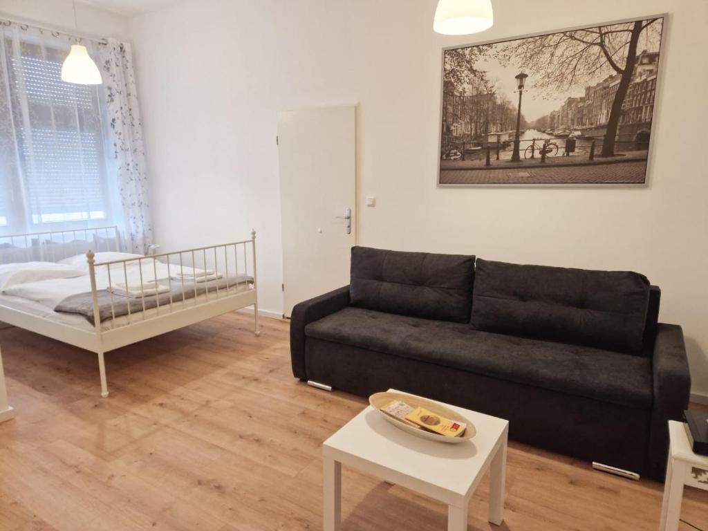 een woonkamer met een bank en een bed bij Family Studio Apartment for 4 in Berlijn