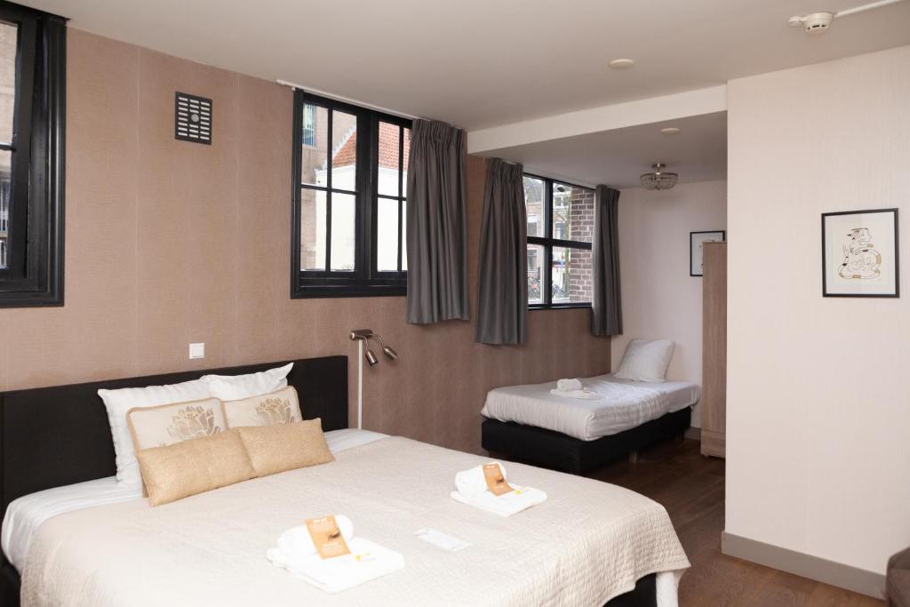 een hotelkamer met 2 bedden en een stoel bij Kings Inn City Hotel Alkmaar in Alkmaar