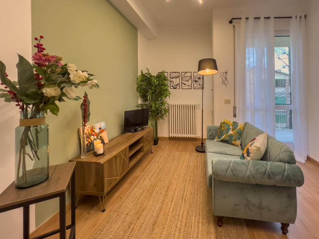 ein Wohnzimmer mit einem Sofa und einem TV in der Unterkunft Appartamento La Marmora - 200 metri Via Camollia in Siena