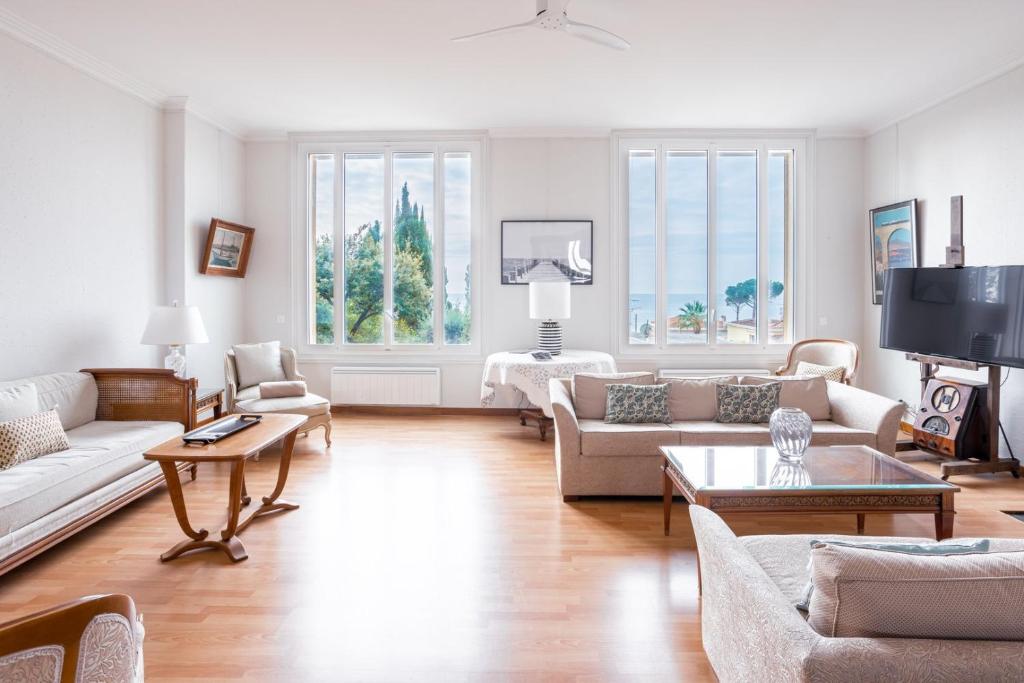 un salon avec des canapés et une télévision dans l'établissement LES PINS un havre de paix près de la plage, luxe pour familles ou petits groupes, à Cannes
