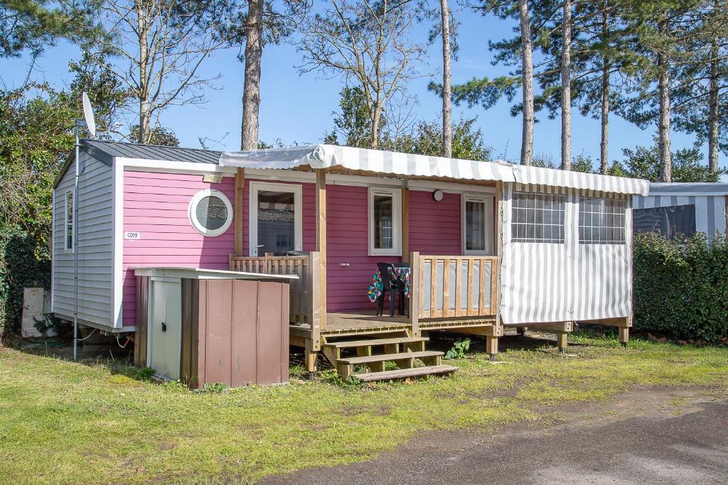 een roze en wit tiny house met een veranda bij New - Mobil home tout équipé in Saint-Jean-de-Monts