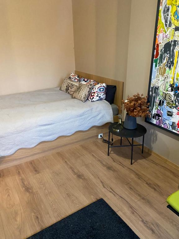 un dormitorio con una cama y una mesa en Roxy’s Kabin, en Jelgava