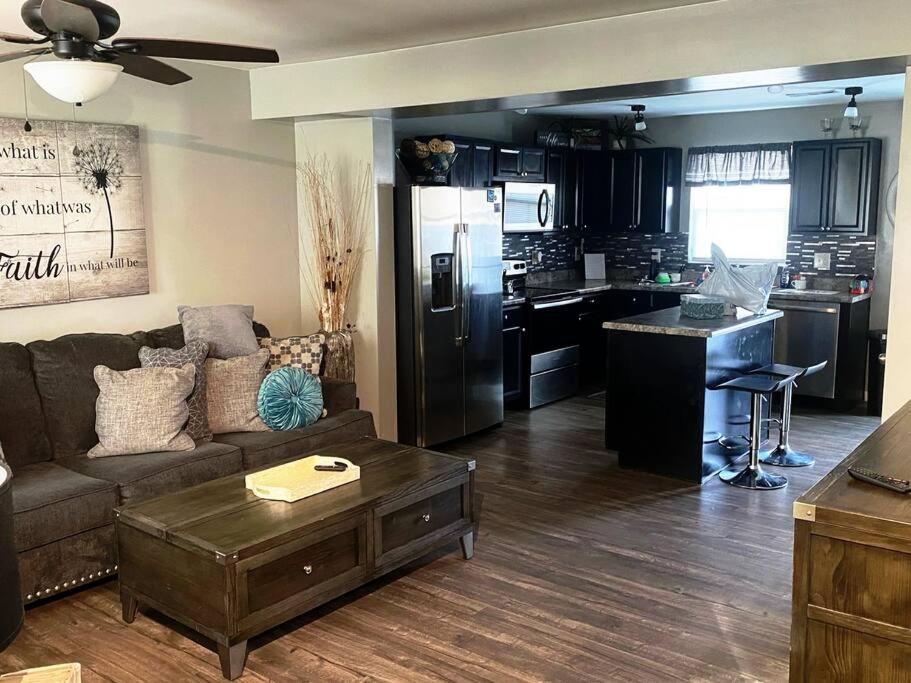 a living room with a couch and a kitchen at Cozy Nest: Where Love Blossoms in Nashville