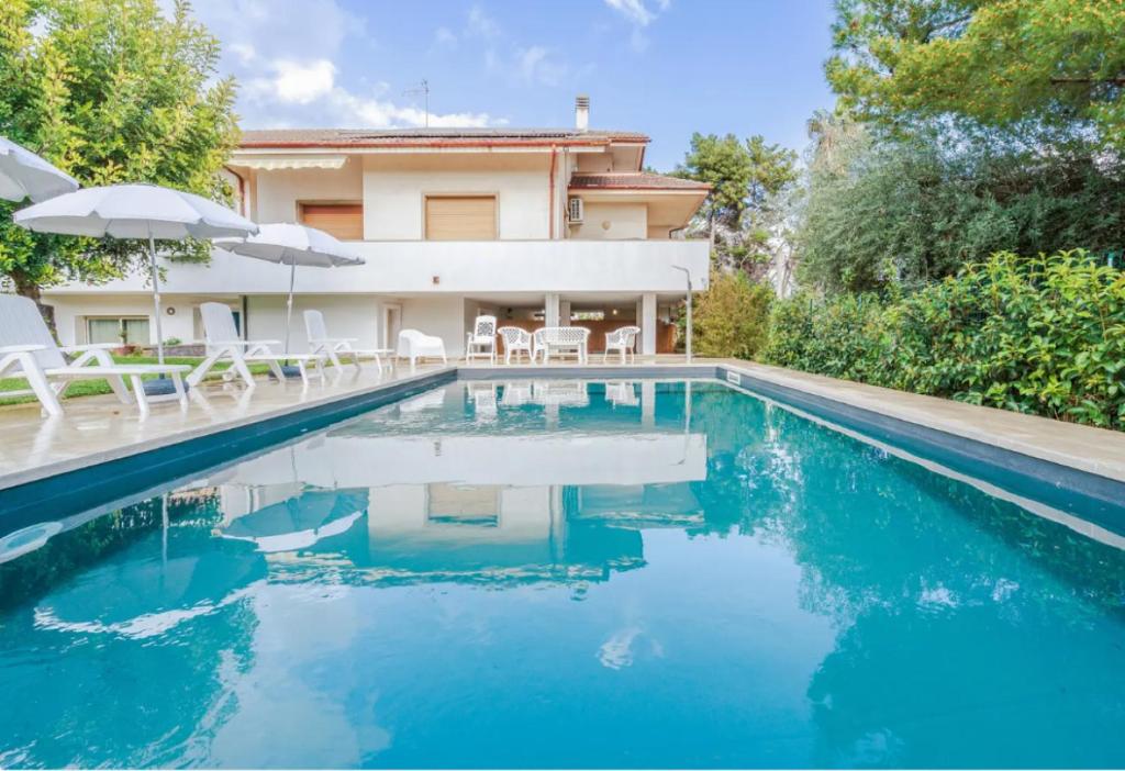 einen Pool mit Stühlen und ein Haus in der Unterkunft Zacchitella Garden House in Rosolini