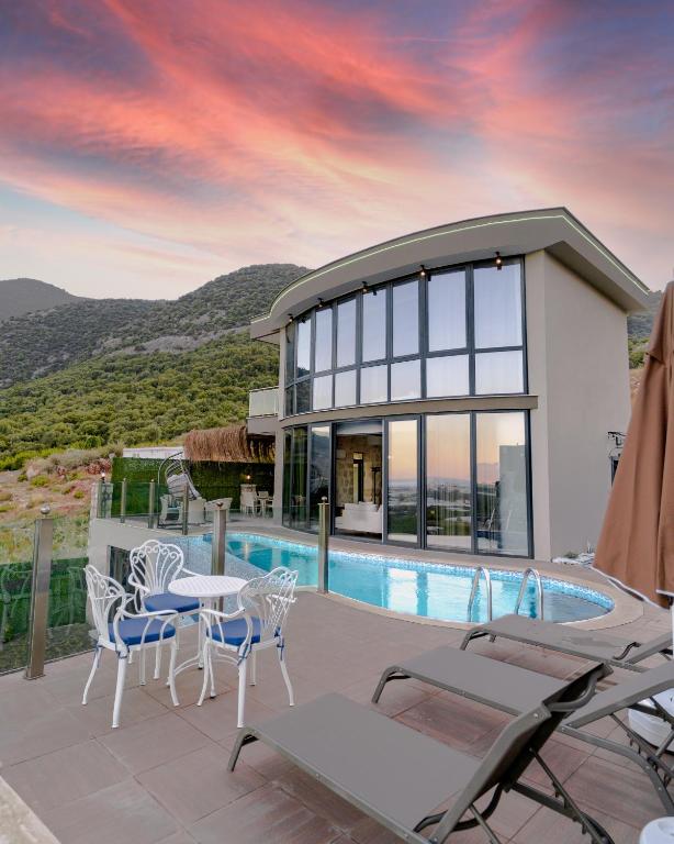 a villa with a swimming pool and a house at Fortunella Villas in Finike