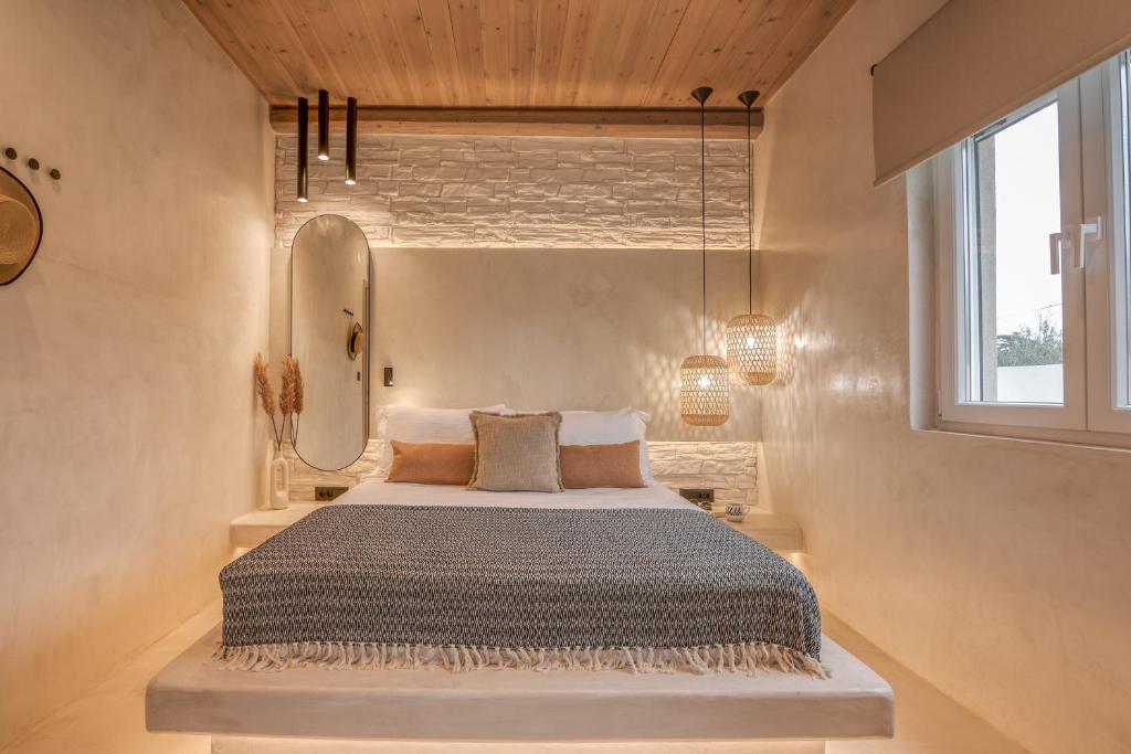a bedroom with a bed with a mirror and a window at Christini Secrets in Plátanos