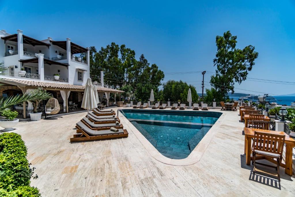 a resort with a swimming pool and lounge chairs at Manzara Boutique Hotel - Adults Only in Bodrum City