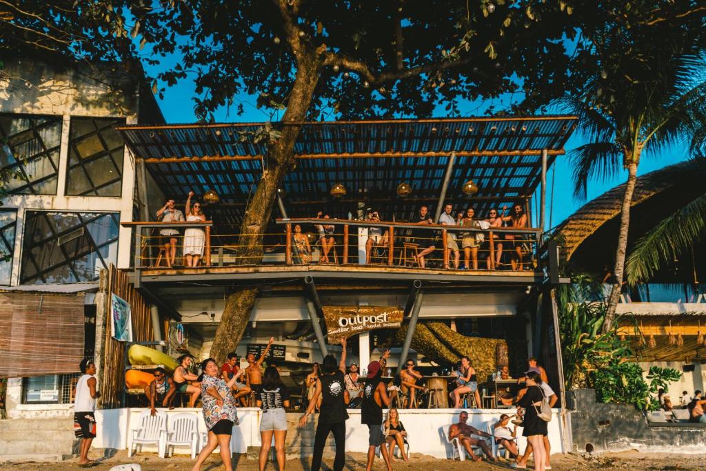 un grupo de personas de pie en frente de un edificio en Outpost Beach Hostel en El Nido